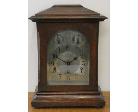 An Edwardian oak chiming mantle clock, the silvered dial with slow/fast and chime/silent dials, the German movement numbered 
