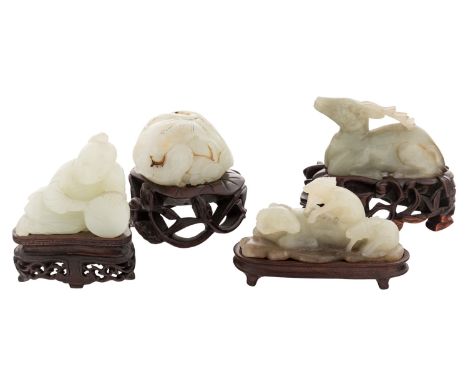 FOUR CHINESE WHITE JADE FIGURES ON STANDS (LATE QING DYNASTY)comprising:a) white jade carved reclining figure with drum; heig