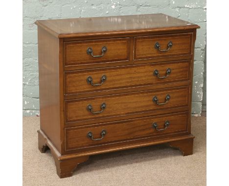 A mahogany crossbanded two over three chest of drawers raised on bracket feet.