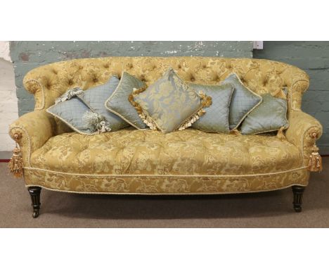 A Victorian gold upholstered deep buttoned parlour sofa raised on turned and ebonized castered legs along with an assortment 