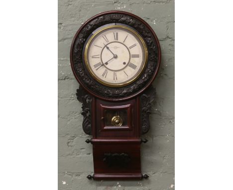 An early 20th century drop dial wall clock with painted rosewood effect case housing a twin train movement.