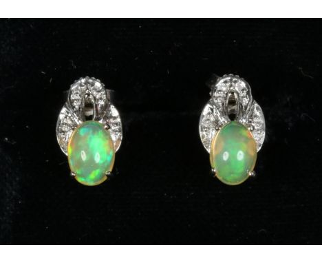 A pair of white gold opal and diamond earrings.