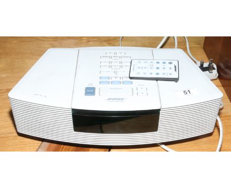 A Bose radio / C.D clock with remote control. Condition Report. To be used as a guide only. C.D player faulty.