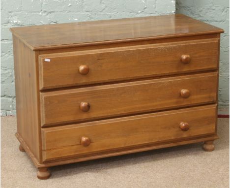 A pine chest of three drawers.
