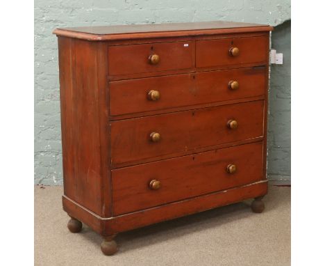 A Victorian painted pine chest of two over three graduated drawers with turned wooden knobs and bun feet.