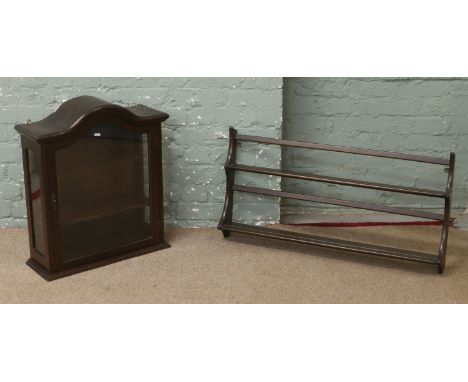 An Ercol mahogany wall mounted plate rack along with a mahogany dome top display cabinet.