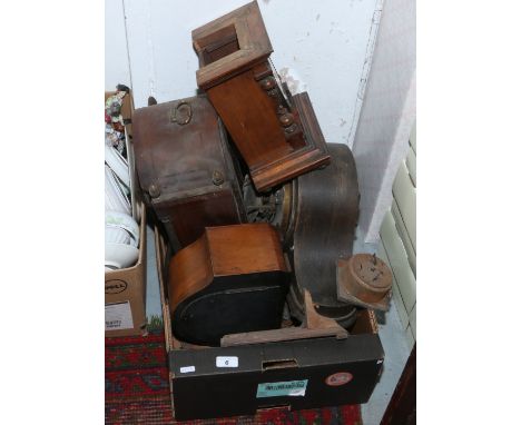 A box of assorted mantel clocks and clock parts.