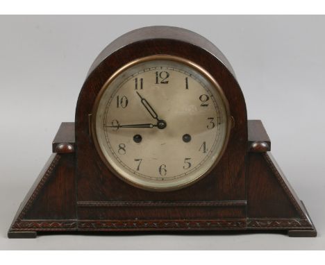 A mid 20th century oak case dome top mantle clock housing a twin train movement.