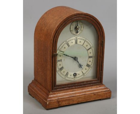 An oak dome top mantle clock, housing single train movement (8 day anchor escapement) with pendulum and key. W & H Sch on mov