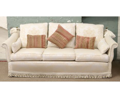 A cream upholstered Milbrook double droparm three seat sofa raised on easy free casters.