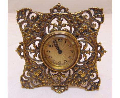 A French brass easel clock with scroll pierced frame the circular engine turned dial with Arabic numerals, 13.5 x 13.5cm
