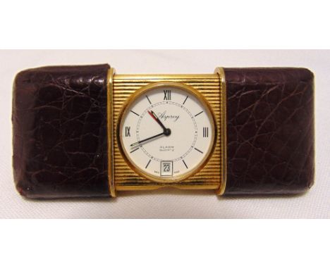 An Aspreys miniature self winding travel clock with crocodile leather case