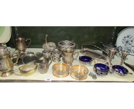 A shelf of assorted metal ware including wine coasters