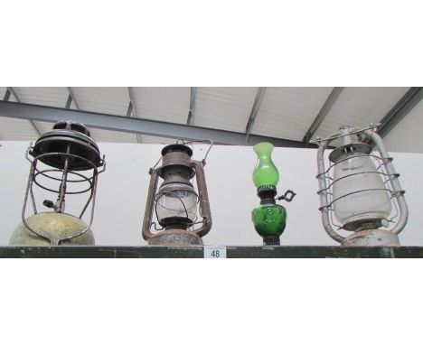 2 storm lanterns, a Tilley lamp and a green glass oil lamp
