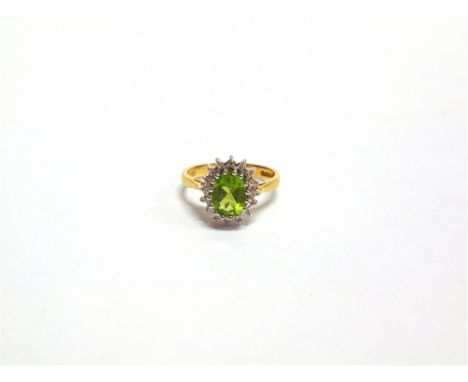 A PERIDOT AND DIAMOND 19 CARAT GOLD CLUSTER RING the oval cut peridot, 8.5mm x 7mm x 3.8mm, enclosed by sixteen single cut di