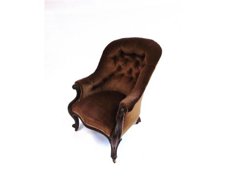 A VICTORIAN BUTTON UPHOLSTERED ARMCHAIR  with carved mahogany frame on cabriole supports with brass casters, 73cm wide