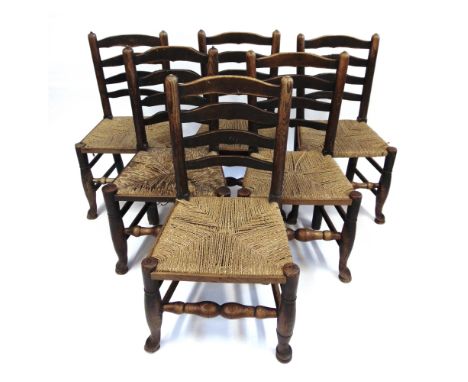 A SET OF SIX ASH FRAMED LADDERBACK DINING CHAIRS  the turned legs united by shaped stretchers Provenance: formerly the proper
