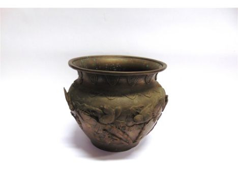 A HEAVY BRASS JARDINIERE  with relief decoration in the Japanese taste depicting birds on branches, 32cm diameter