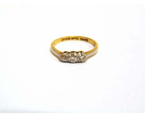A THREE STONE DIAMOND RING stamped '18ct' and 'Plat' with graduated single cuts and a brilliant cut diamond, finger size K, 2