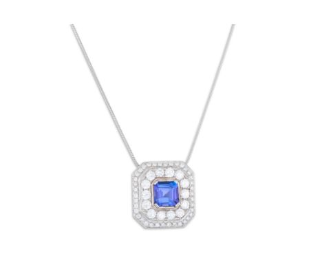 A TANZANITE AND DIAMOND CLUSTER PENDANT, the trap cut tanzanite to a two rowed diamond surround, mounted in 18ct white gold, 