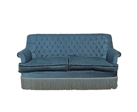 Cypriot, Pambos Savvides two seater sofa, buttoned back, loose seat cushions, blue velvet upholstery with a long silk fringe 