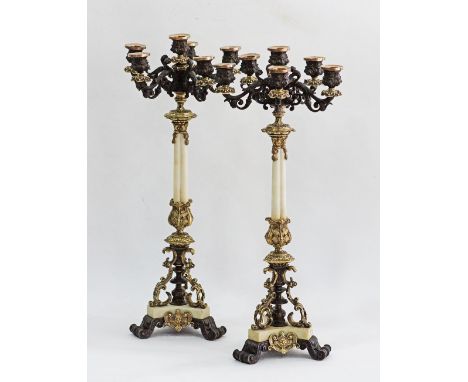 A pair of French Restoration, gilt and patinated metal mounted and white marble six light candelabra, circa 1830, each with e