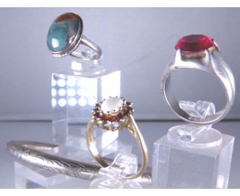 Three silver rings and a silver bangle 