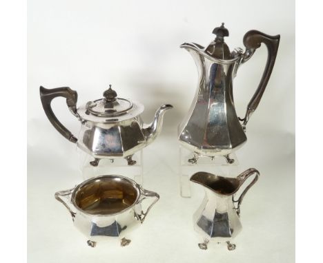 AN EARLY 1900's MATCHING FOUR PIECE SILVER TEA AND COFFEE SERVICE, each of polygonal form standing on four pierced pad feet o