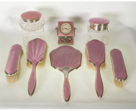 AN EIGHT PIECE SILVER AND GUILLOCHE PINK ENAMELLED SUITE OF DRESSING TABLE ITEMS, COMPRISING; A HAND MIRROR, TWO HAIR BRUSHES