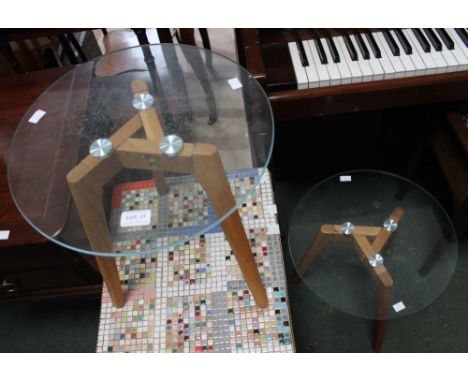 A pair of modern wooden tripod side tables with circular glass tops