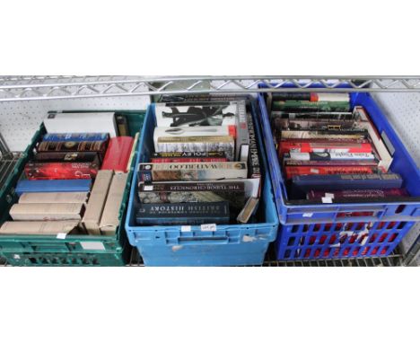 A shelf containing three plastic crates of mixed hardback, mainly non fiction books