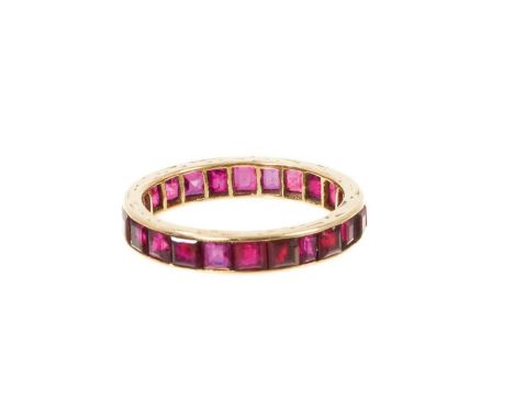 Ruby eternity ring with a full band of calibre cut rubies in yellow gold setting, ring size P.