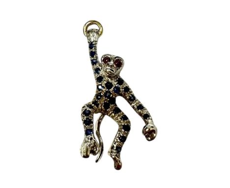Gold (18ct) novelty pendant in the form of a swinging monkey suspended from a gold ring with ruby eyes and pavé set sapphire 
