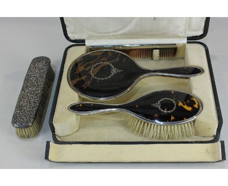 A George V silver and tortoiseshell dressing table mirror and brush, with laurel inlay to backs, in fitted case, together wit