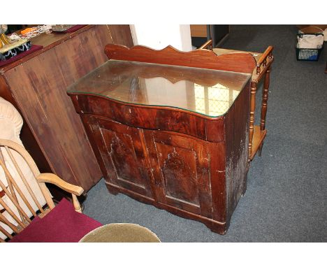 A Victorian mahogany washstand with serpentine shaped top and raised back, frieze drawer above twin arch panelled cupboard, o