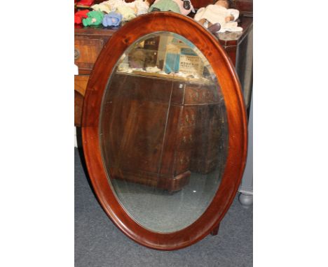 A large mahogany framed oval wall mirror, bevelled glass, mirror plate 85.5cm by 57.5cm
