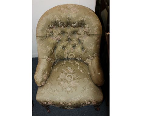 A Victorian button upholstered armchair in floral green upholstery, on turned legs and castors