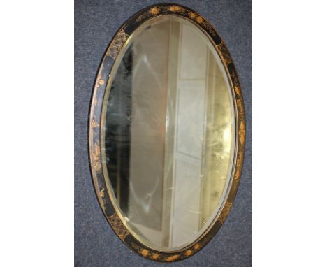 A chinoiserie black lacquered oval wall mirror, mirror plate 74cm by 47cm