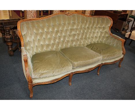 A French style three-seater button upholstered settee with carved show wood frame, on six cabriole legs, 185cm