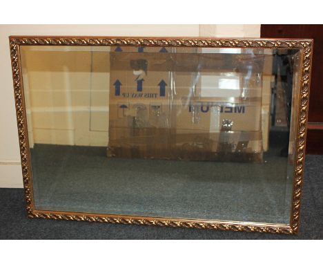 A gilt framed rectangular wall mirror with scrolling foliate decoration, mirror plate 50cm by 74.5cm