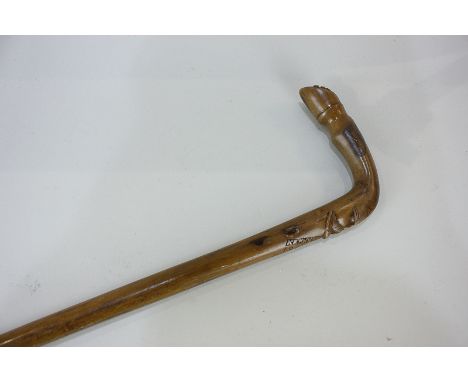 A carved wood walking stick, the handle carved with a gentleman's face, terminating in a horse's hoof, inscribed 1918 Corfu R