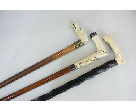 A walking stick with bone handle carved in the form of a greyhound, and two other bone handled walking sticks, one with barle