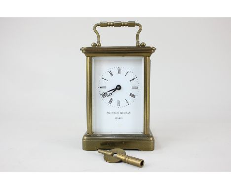 A brass and bevelled glass cased carriage clock, the dial marked Matthew Norman, London, with Roman numerals and key wind mov