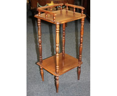 A mahogany two-tier occasional side table with three-quarter gallery back, shaped rectangular top and under shelf, on turned 