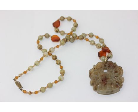 A carved and pierced jade pendant on a hardstone bead neck chain