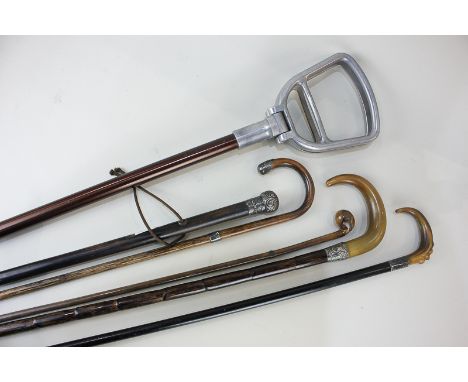 A silver mounted cane (marks worn), together with three walking sticks, two with horn handles, a cane, and a shooting stick (