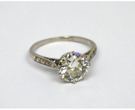 A platinum ring set with an antique-cut round solitaire diamond, with diamond-set shoulders, size M 1/2, approx 3.05ct, appro