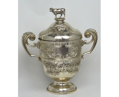 An Edward VII hallmarked silver twin-handled presentation trophy with repoussé floral decoration and cow finial, inscribed in