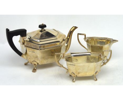 An Elizabeth II hallmarked silver three-piece tea service, to include teapot, sugar bowl and milk jug, octagonal form on paw 