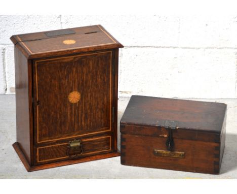 An early 20th century oak inlaid cigarette cupboard with vintage pipes to interior, silver plaque to top inscribed 'Presented